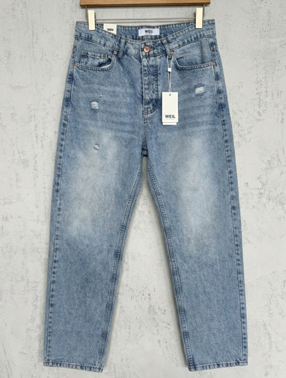 Pair of light blue jeans with a tag on a gray background